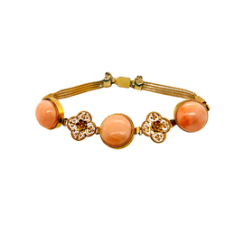 14K gold and coral bracelet featuring alternating filigree medallions and braided chain details