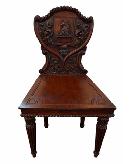 English William IV mahogany hall chair with carved heraldic shield back, horse‑head crest, acanthus foliage, solid seat, and fluted turned legs, circa 1830