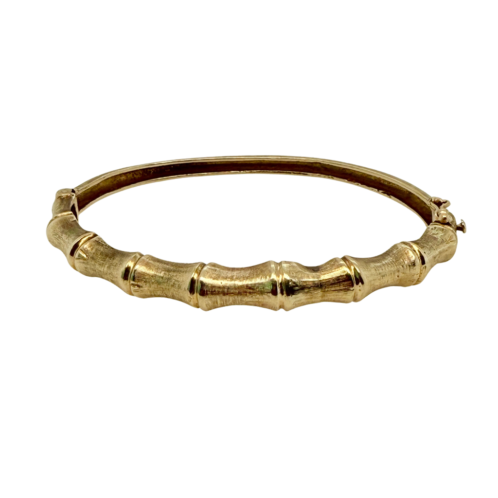 Front view of a vintage 14K yellow gold bangle bracelet with a sculpted bamboo design across the top