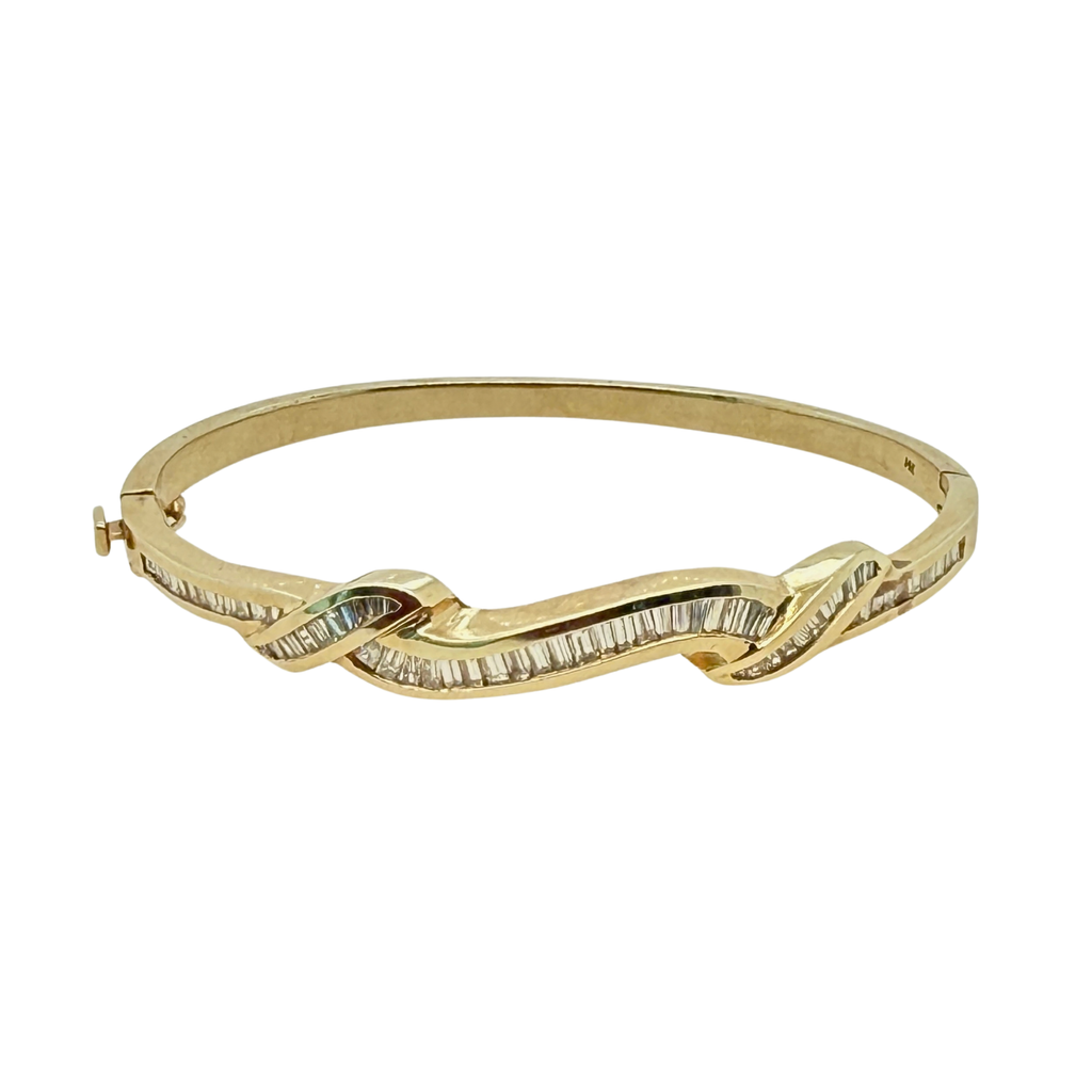 Front view of a vintage 14K yellow gold bangle bracelet with channel-set baguette diamonds in an undulating ribbon design
