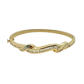 Front view of a vintage 14K yellow gold bangle bracelet with channel-set baguette diamonds in an undulating ribbon design
