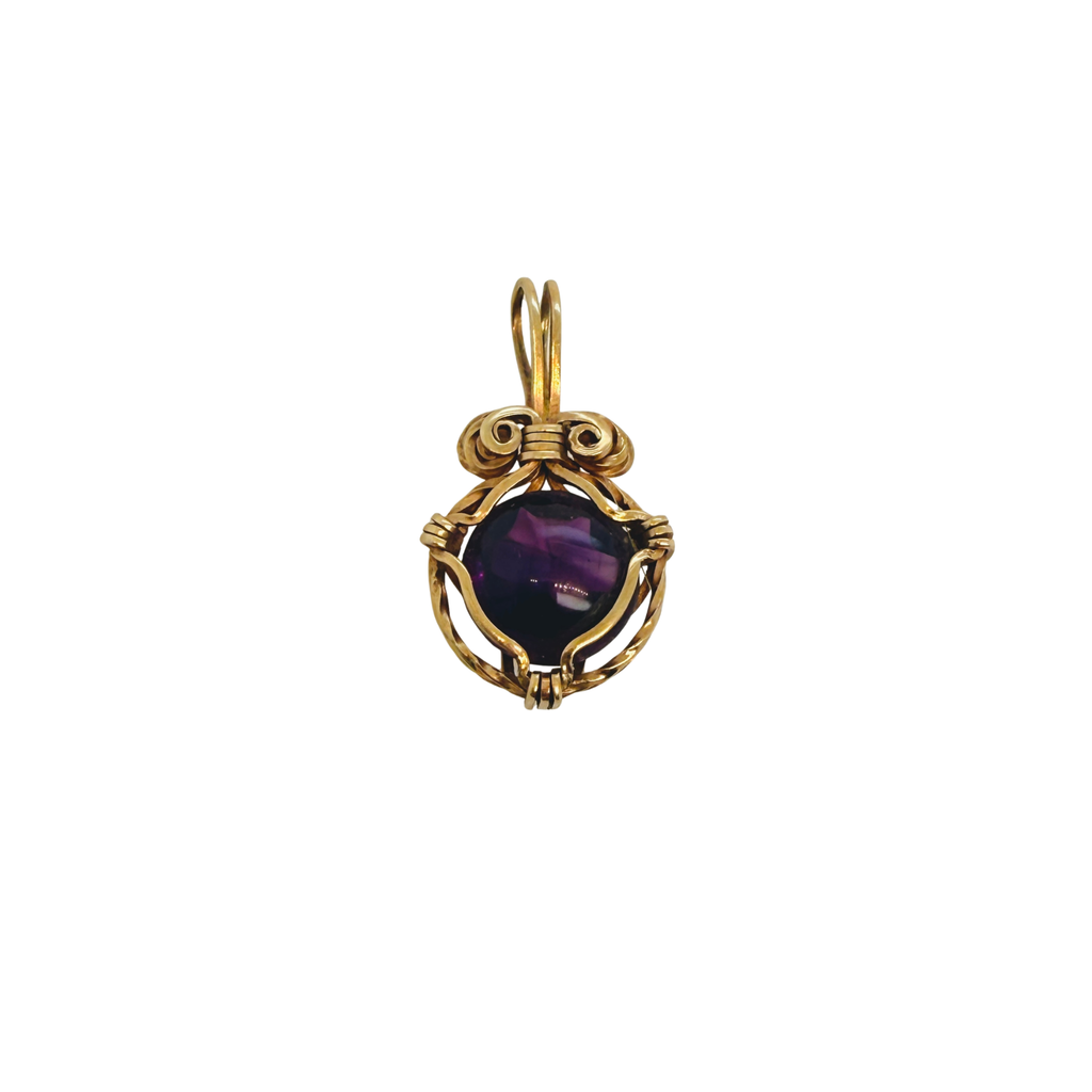 Front view of a vintage 14K yellow gold pendant set with a polished purple amethyst cabochon