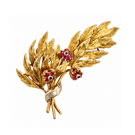 Front view of a vintage 18K yellow gold leaf spray brooch with three ruby and sapphire flowers
