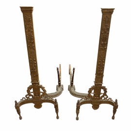 Pair of ornate bronze fire dogs on a white background