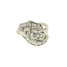 An Art Deco style diamond ring featuring a central round diamond surrounded by smaller round and baguette-cut diamonds set in a silver-toned metal band, shown on a plain white background.