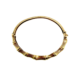 Side profile of a hinged yellow gold bamboo bangle bracelet showing its slim 6.5 mm width