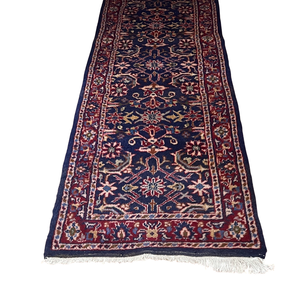 View of one end of Vintage Persian Runner Carpet with geometric pattern in red and blue