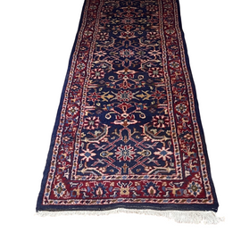 View of one end of Vintage Persian Runner Carpet with geometric pattern in red and blue