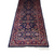 View of one end of Vintage Persian Runner Carpet with geometric pattern in red and blue