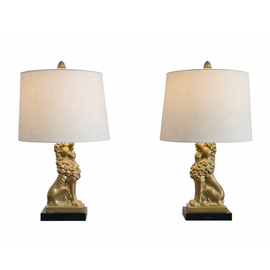 Pair of mid‑century patinated metal table lamps with seated gold lion bases on black plinths and beige drum shades.