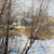 Oil on canvas winter landscape featuring a weathered building and trees