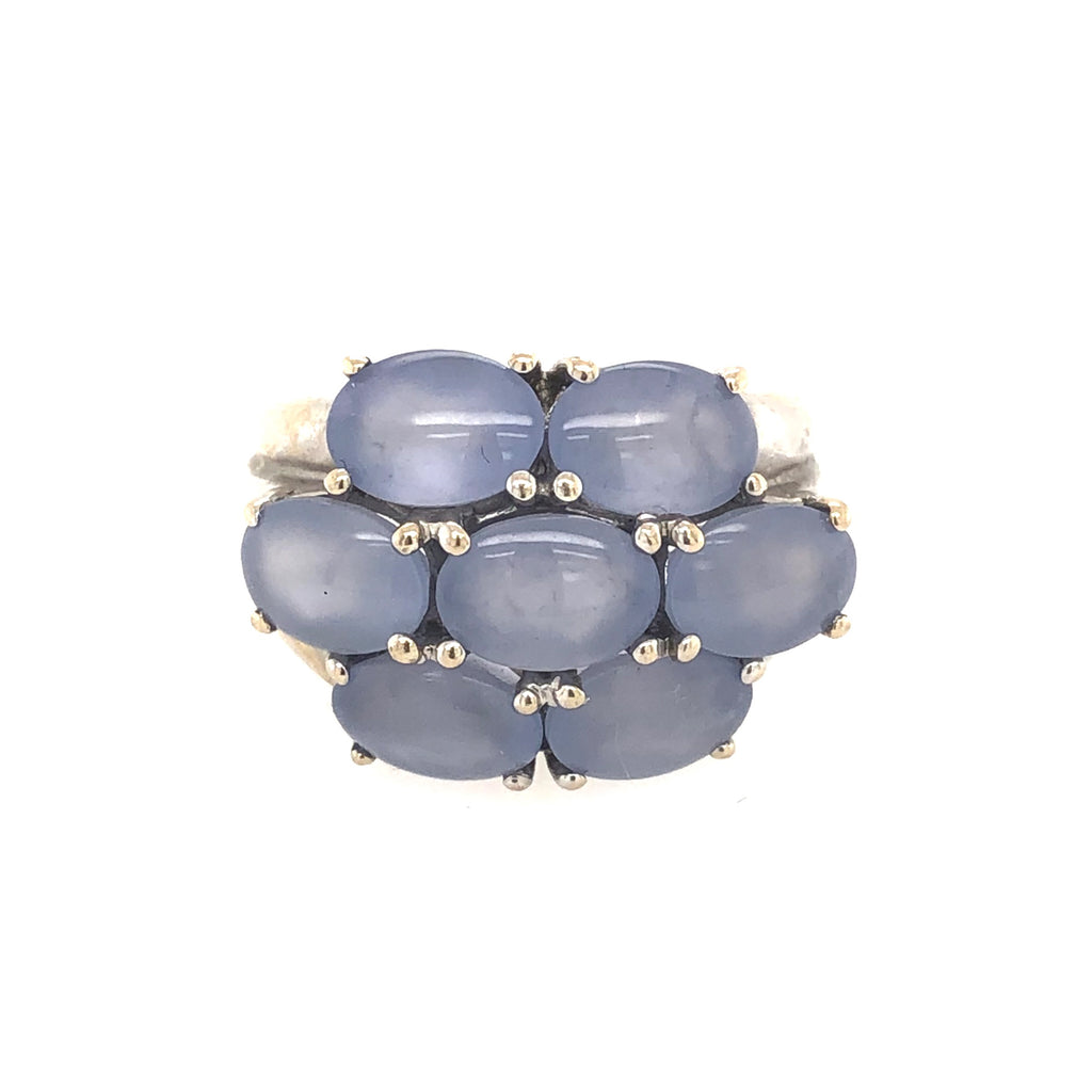 Front view of an 18K white gold ring with seven prong set cabochon blue chalcedony stones